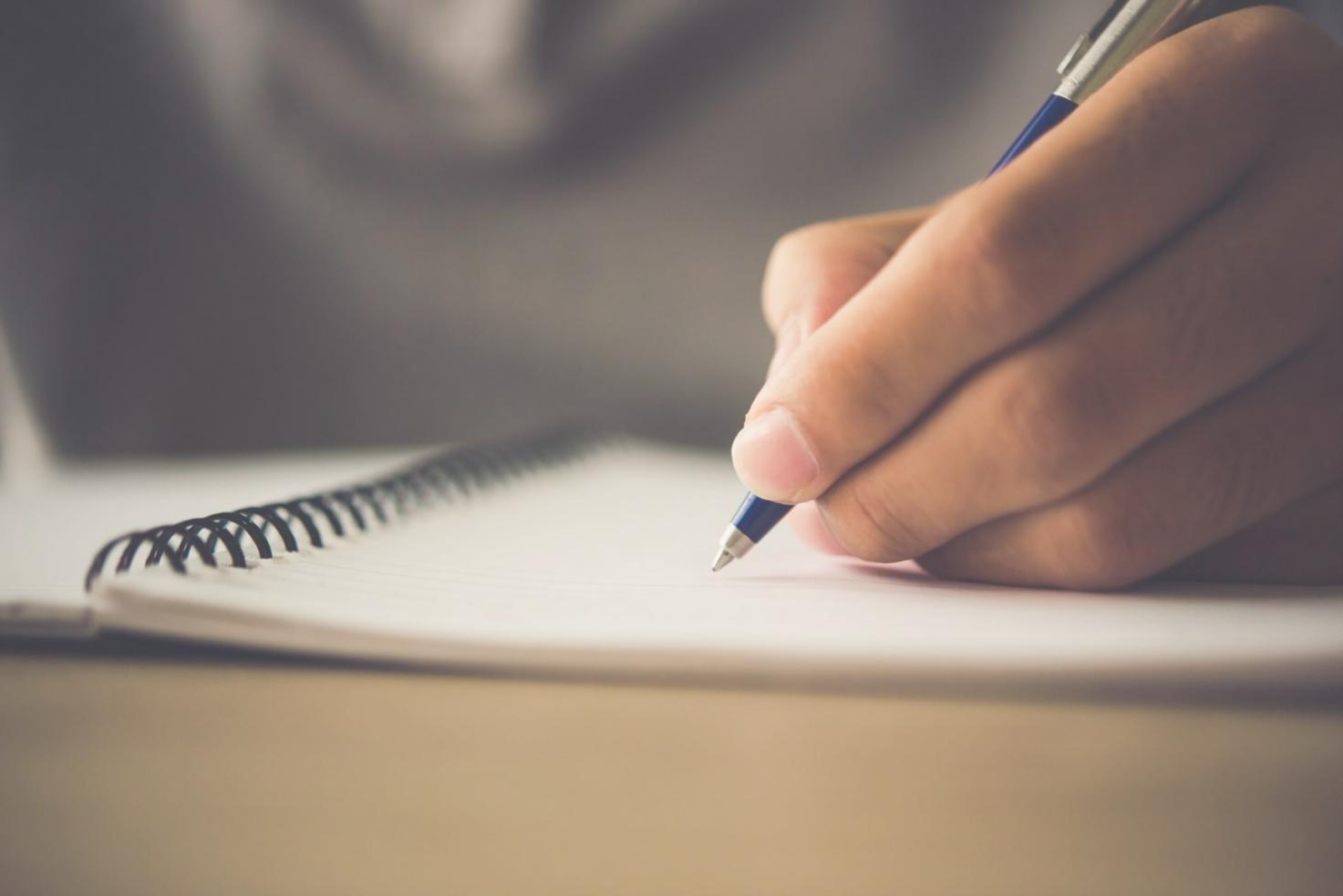 Person beim konzentrierten Arbeiten mit Finanzunterlagen